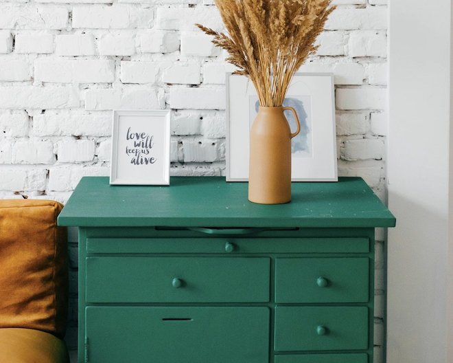 A dark green drawer with a flower pot on top